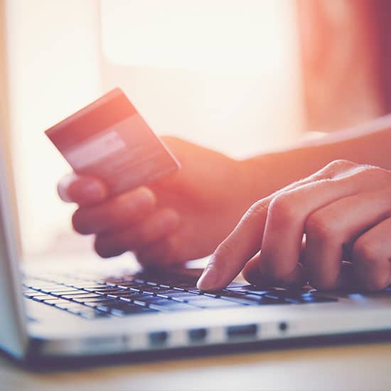 close up of person using laptop, credit card in hand