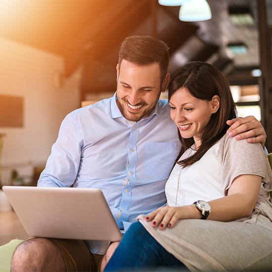 happy middle aged couple looking at laptop together