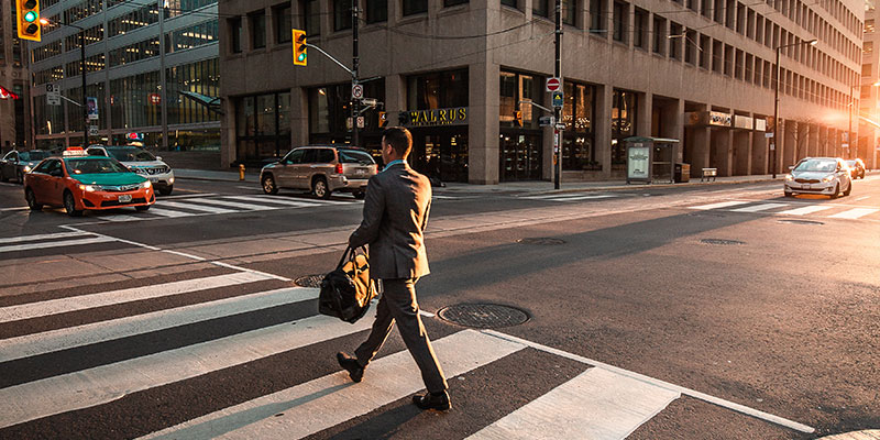 businessman walking across the crosswalk