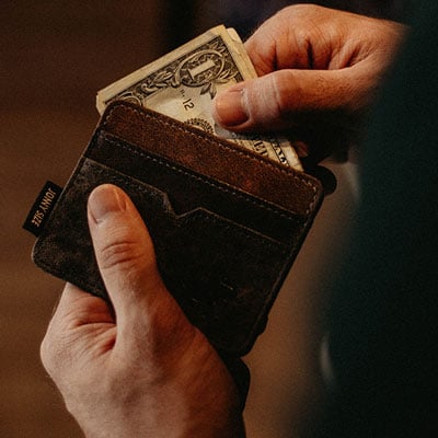 man holding wallet with cash in it