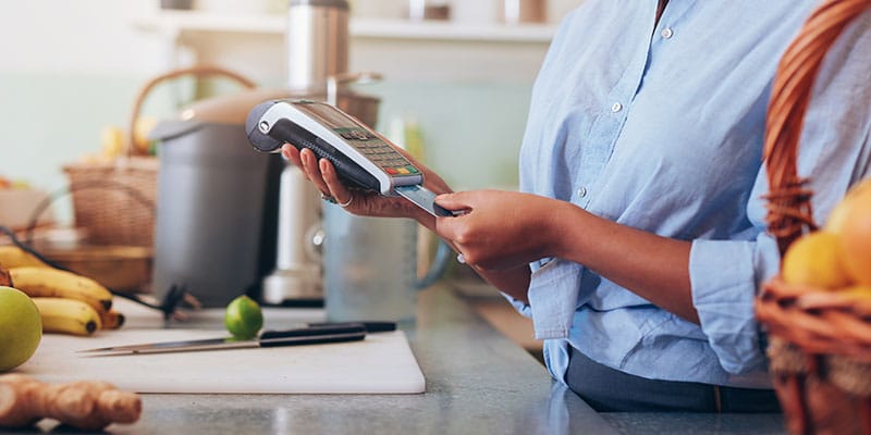 woman making a debit card purchase in store