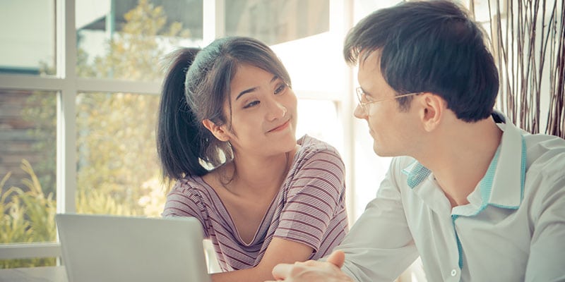 smiling couple looking over their finances together