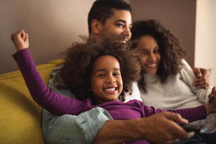 happy family snuggling and laughing together on their couch