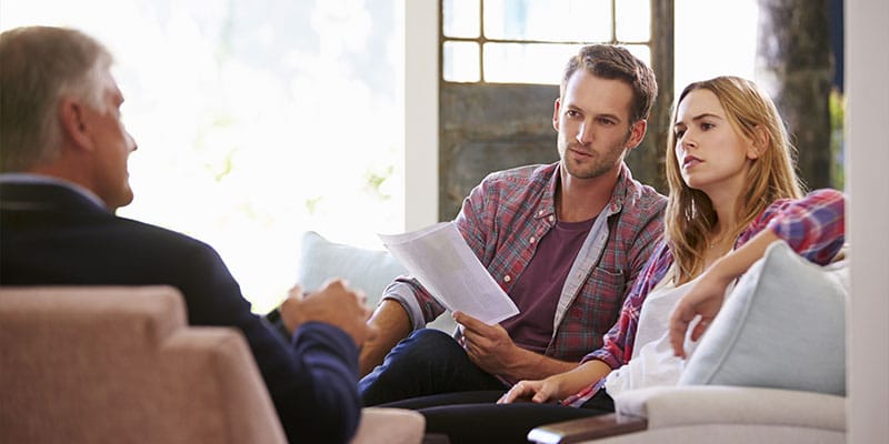 couple visiting with a mortgage officer, going over paperwork