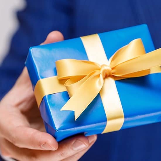 man holding a blue gift box with a gold ribbon