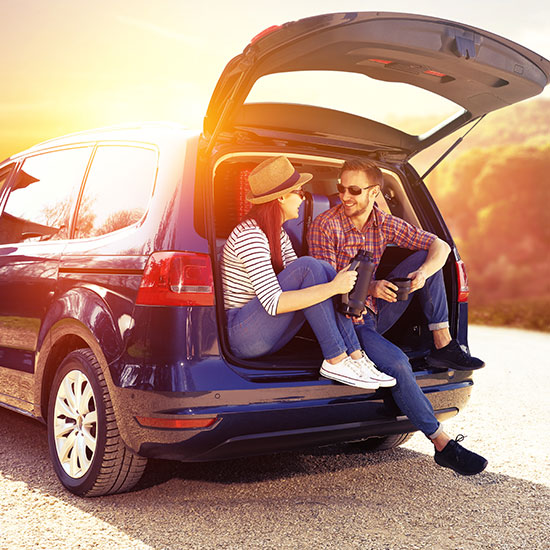 couple sitting in the back of their new minivan