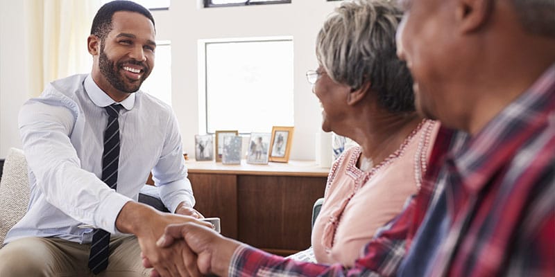 senior couple shaking hands with a financial advisor