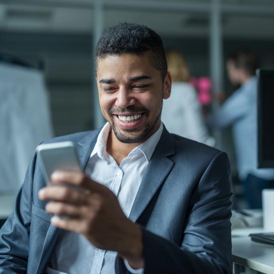 man wearing a suit checking his mobile phone at work