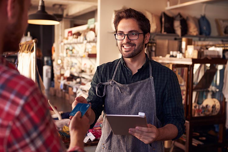 man handing his credit card to retail associate