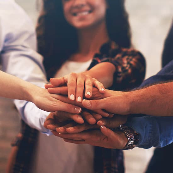 group of hands stacked on top of each other