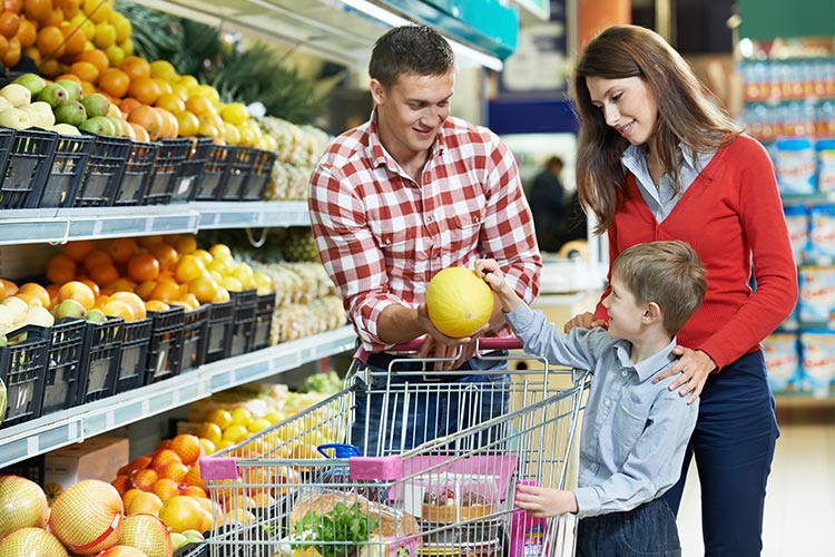 mother and father with their young son at the grocery store