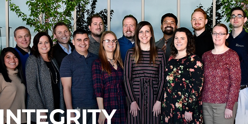 group of DFCU employees smiling, with text overlay: Integrity