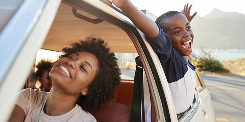 mother driving her kids on a road trip