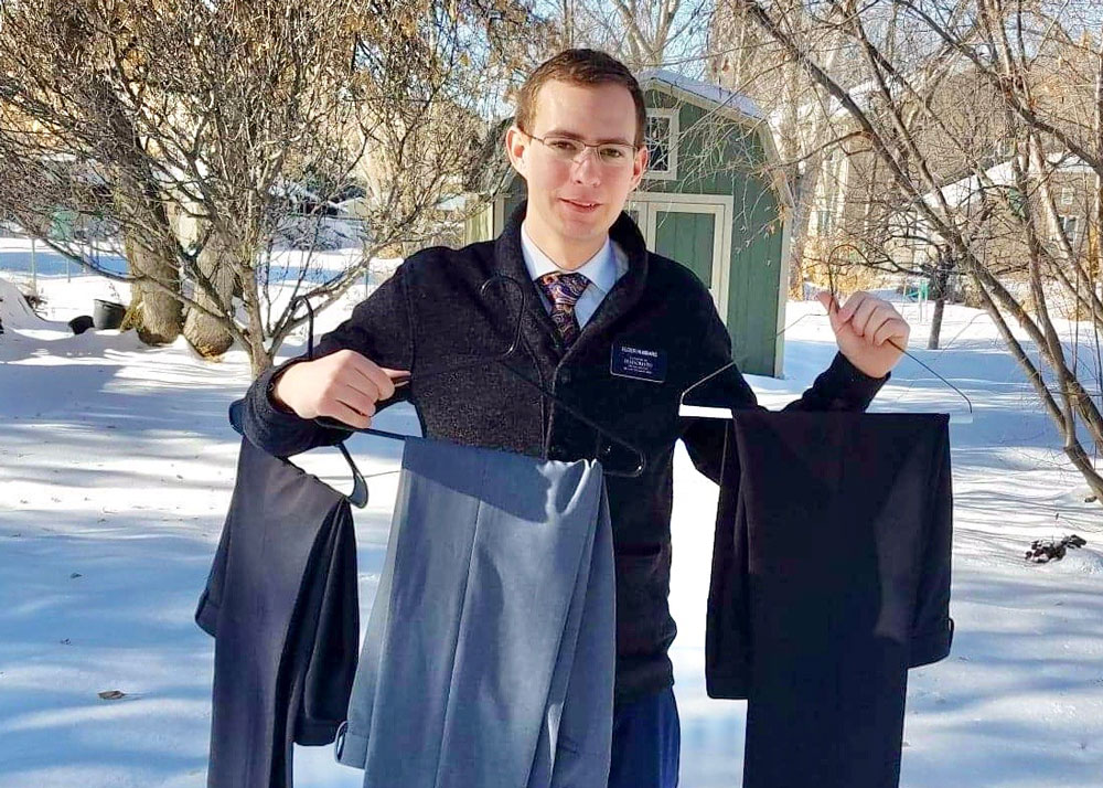 A missionary in winter showing off new pairs of slacks