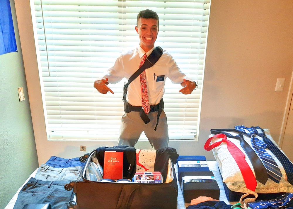 An excited missionary showing all of the newly donated items on his bed