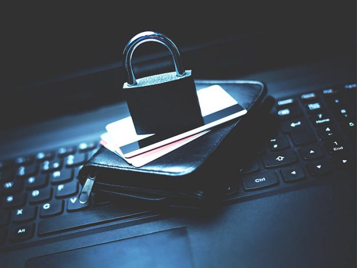 Wallet and Credit Cards with a lock sitting on a keyboard.