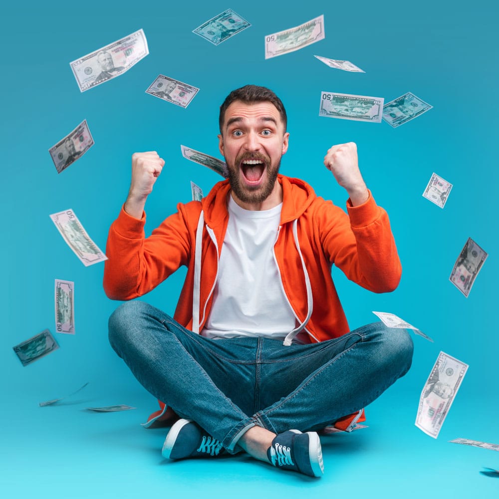 A man sitting on the floor being showered in cash