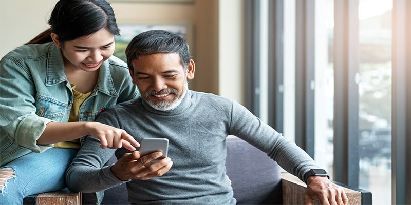 daughter teaching dad about finances on his phone