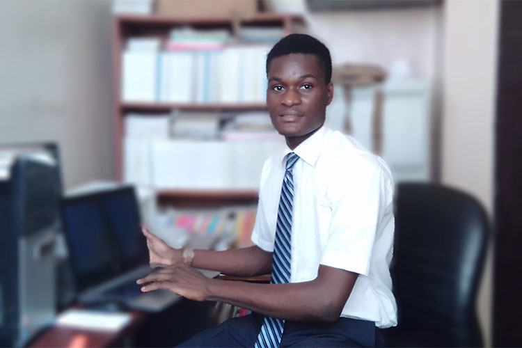 A missionary sitting at a desk looking at the camera