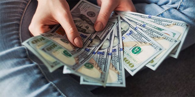 A woman fanning out several bank notes.