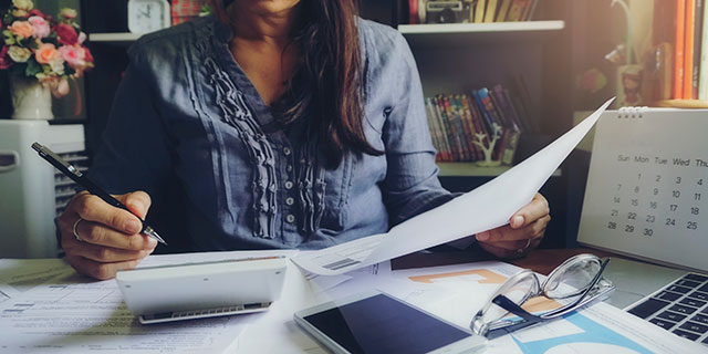 A woman at her desk doing tax calculations