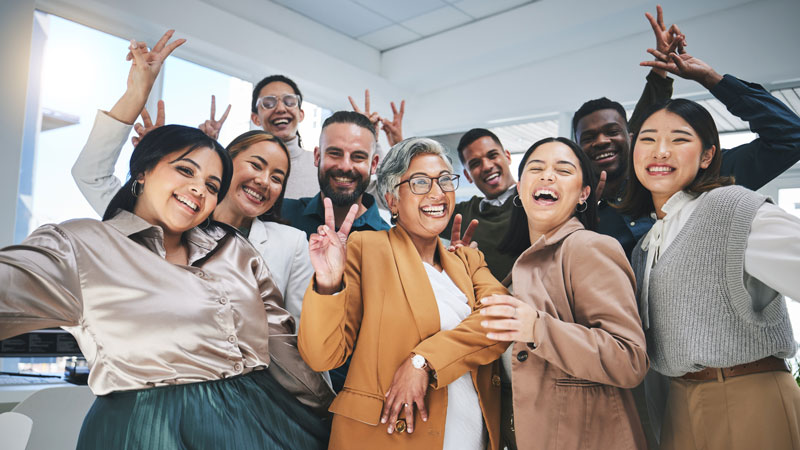 Group of employees smiling and throwing peace signs